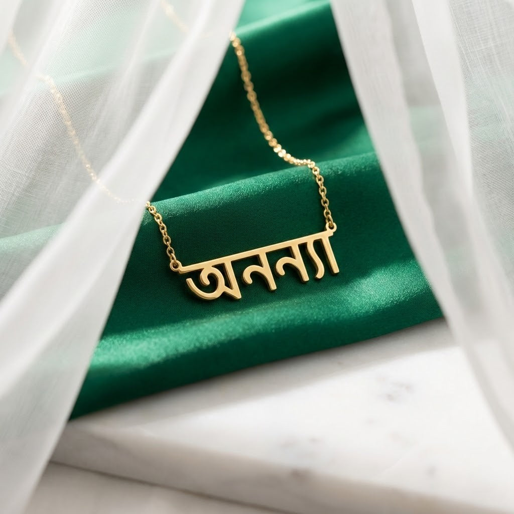 Gold-plated Bengali name necklace, name in Bengali script on velvet by a sheer curtain