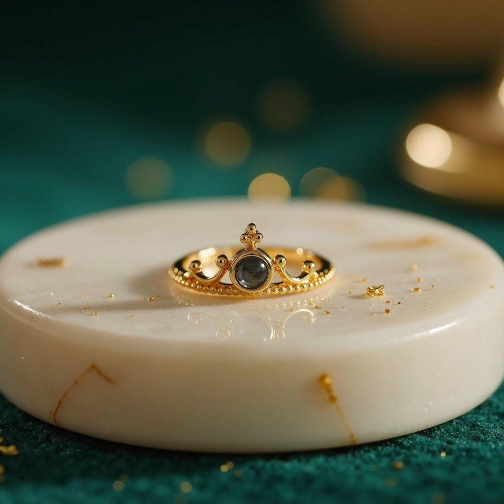 Crown projection ring with a hidden photo in the round stone, gold-tone crown band, on a marble disc