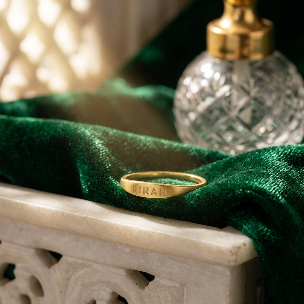 Slim gold name ring engraved KIRAN on green velvet