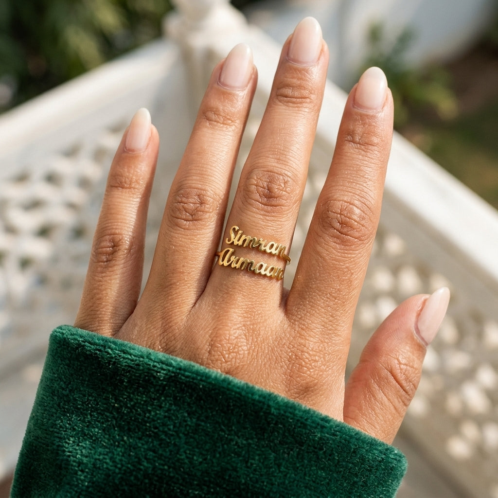 Gold double name ring with Simran and Armaan worn on the hand