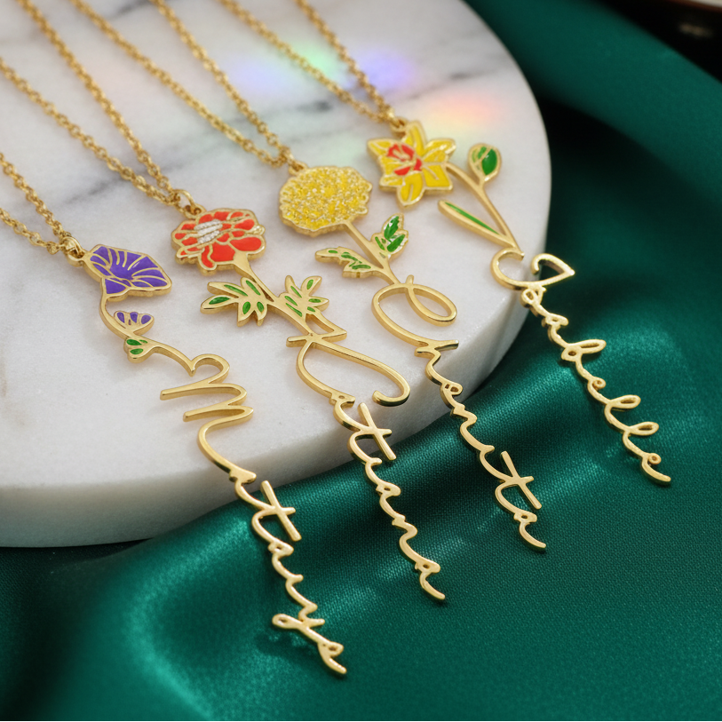 Birth flower name necklace: coloured birth flower with a name below, gold-tone, four necklaces on a marble disc with different flowers and names