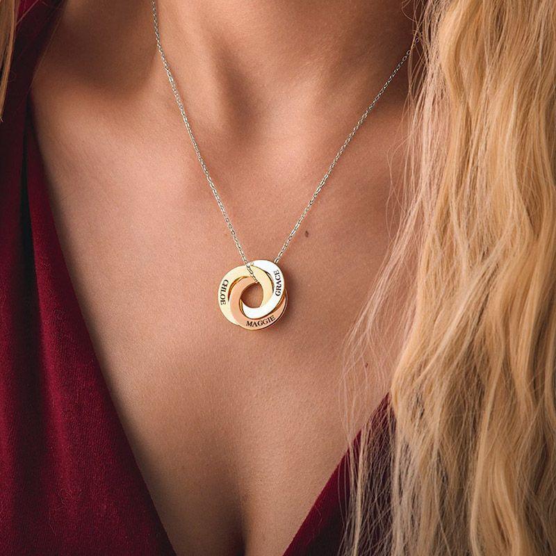 Linked circles necklace: three interlocking rings engraved with names such as 'Dilpreet' and 'Harleen', worn with a red top