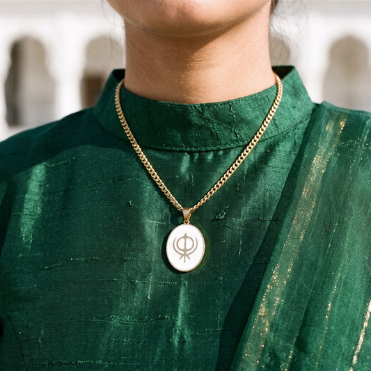 Khanda enamel pendant necklace worn with a green suit