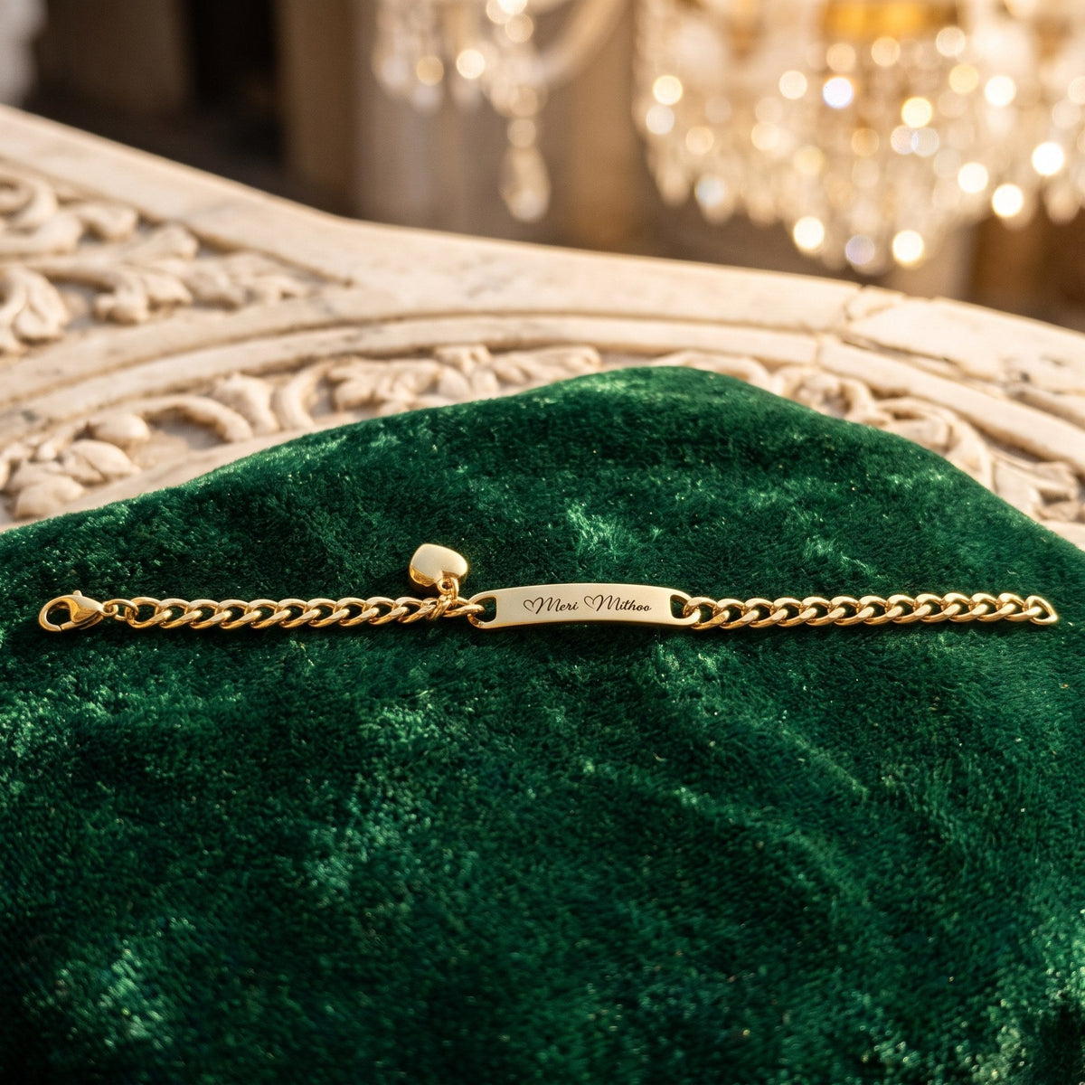The whole gold heart charm name bracelet laid flat on green velvet