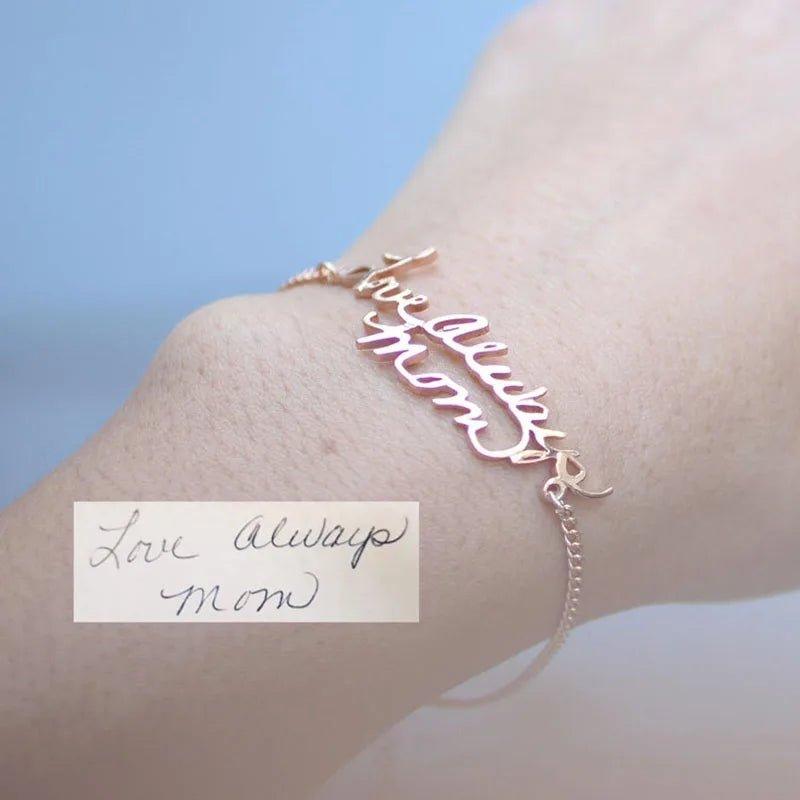 Scripted bracelet: gold-tone chain bracelet cast from actual handwriting, 'Love always Mom' in a rose-gold-tone, worn on a wrist, with the handwriting shown
