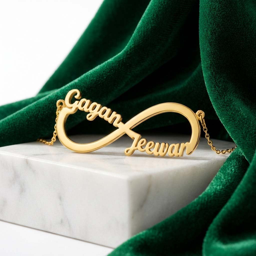 Gold-plated infinity name necklace with two names 'Gagan' and 'Jeewan', on marble with green velvet