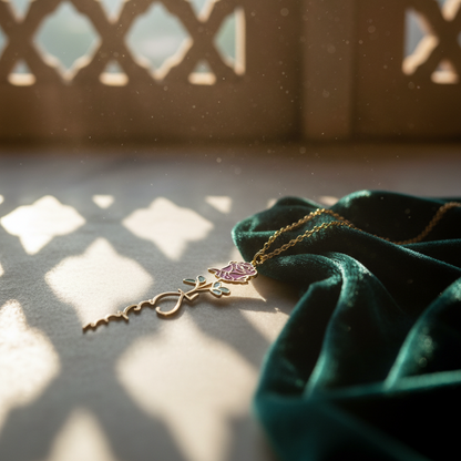 Gold necklace with a purple pendant on a green fabric against a decorative window.