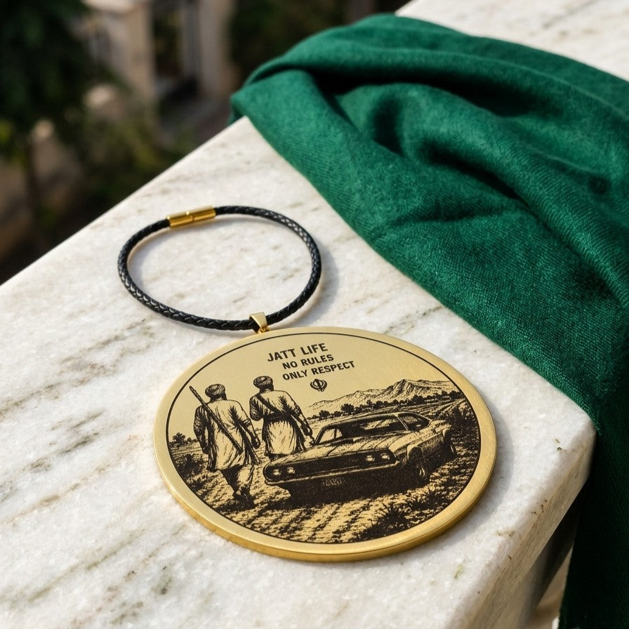 Round gold car hanging with the Jatt Life design on a black thread