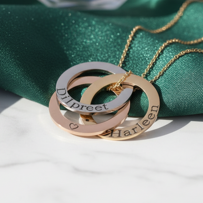 Gold necklace with interlocking rings on a green fabric background