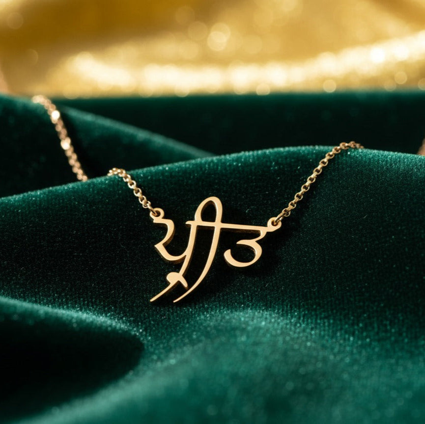 Gold necklace with a unique design on a green fabric background