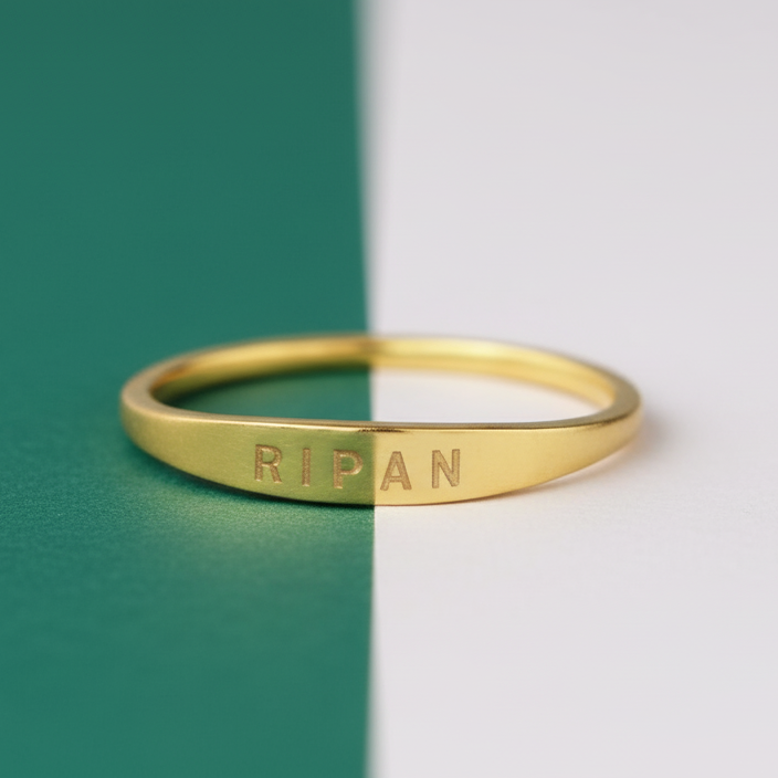 Gold ring with engraved text on a green and white background