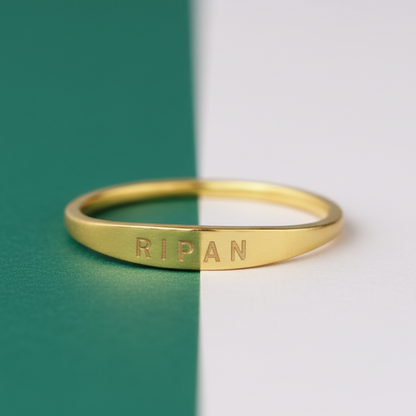Gold ring with engraved text on a green and white background