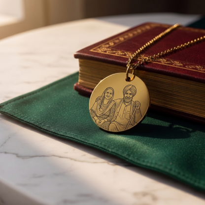 Gold necklace with a pendant featuring engraved portraits on a green cloth with a book in the background.
