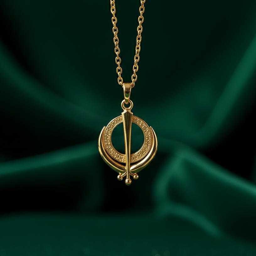 Gold necklace with a circular pendant on a green fabric background