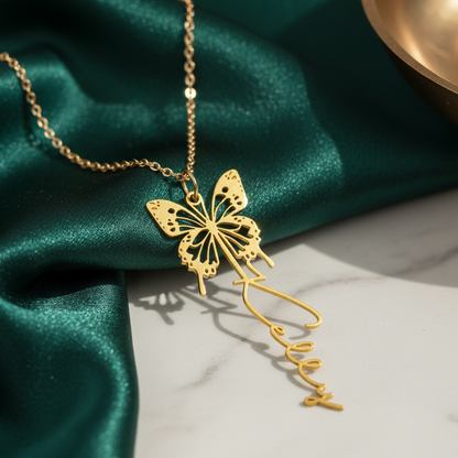 Gold butterfly necklace on green fabric