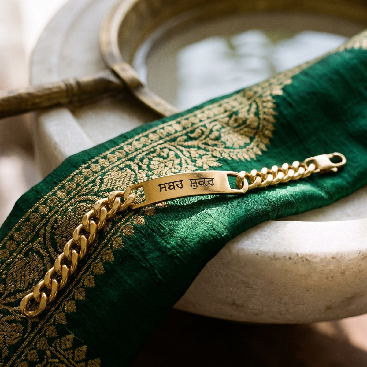 Gold curb name bracelet on green silk with a gold border