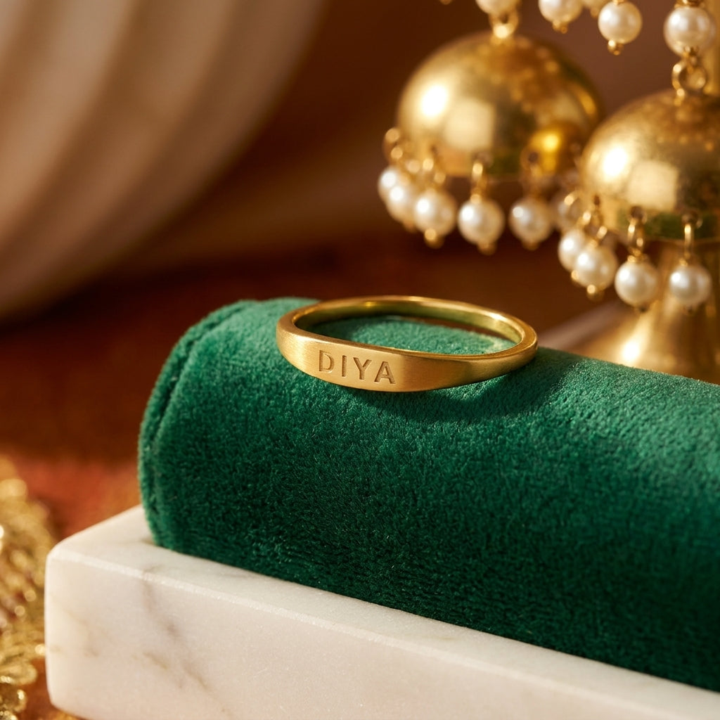 Slim gold name ring engraved DIYA on green velvet