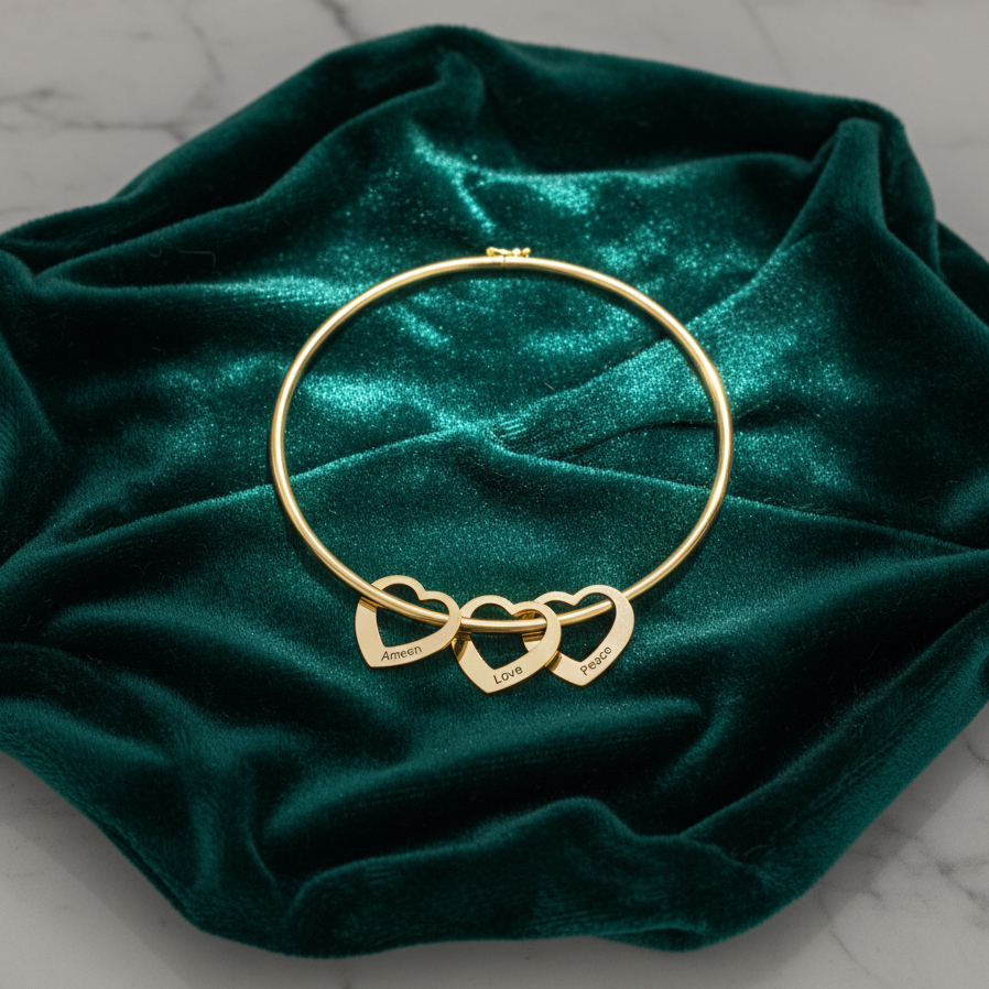 Gold bracelet with heart charms on a green velvet surface