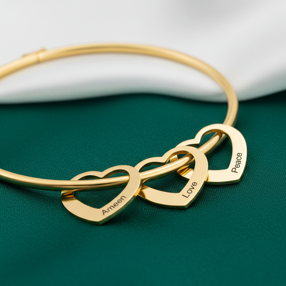 Gold bracelet with interlocking heart charms on a green surface