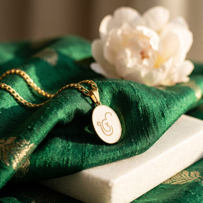 Ik Onkar enamel pendant on green silk with a white flower