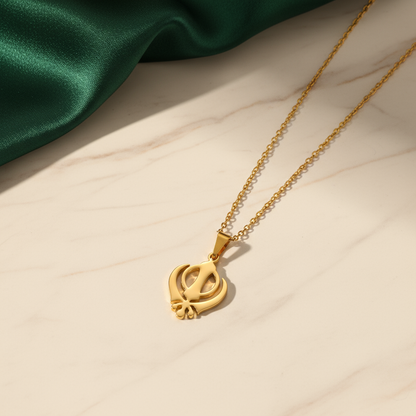 Gold necklace with a heart-shaped pendant on a beige surface