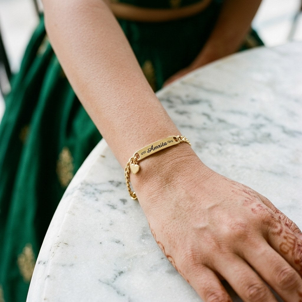 Gold heart charm name bracelet on a woman's wrist