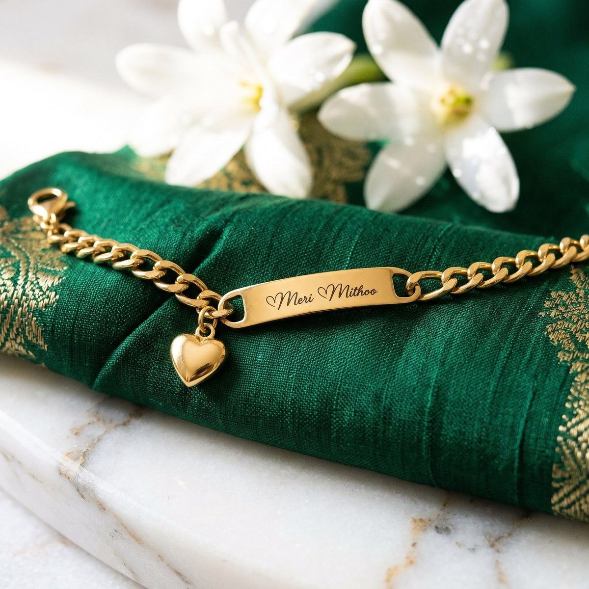 Gold heart charm name bracelet on green silk with white flowers