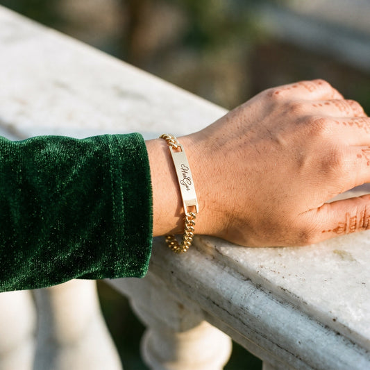 Gold name ID bracelet with HarGur on a woman's wrist with mehndi