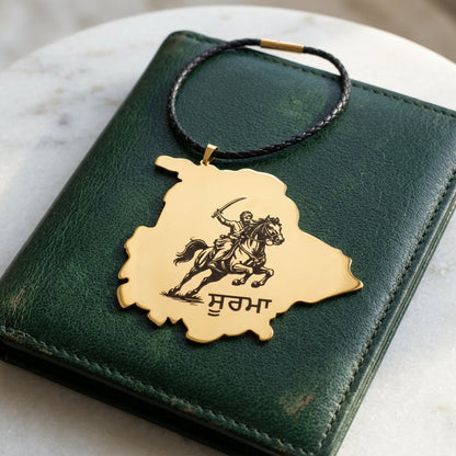 Gold Punjab map car hanging engraved with a Sikh horse rider and the word ਸੂਰਮਾ