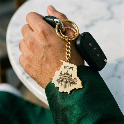 Golden Temple Punjab map keychain hanging from a hand that holds a car key