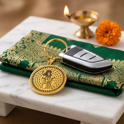 Hanuman Ji round gold keychain with a car key, a diya and a marigold