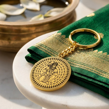 Round gold keychain engraved with Hanuman Ji and Ram, on a green silk cloth