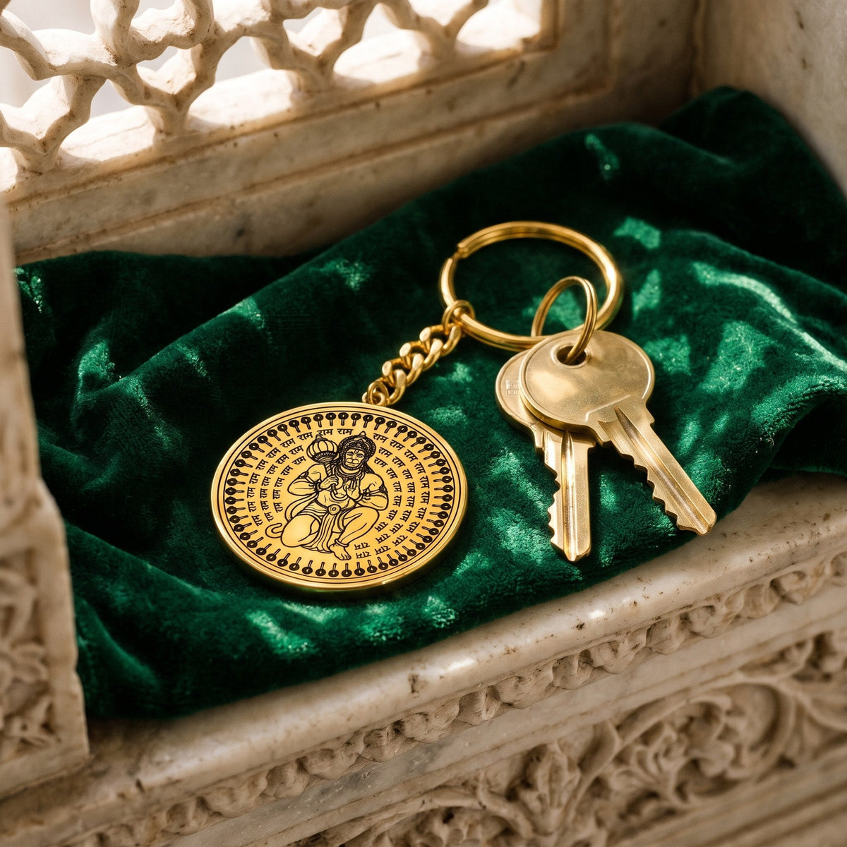 Hanuman Ji round gold keychain with house keys on green velvet
