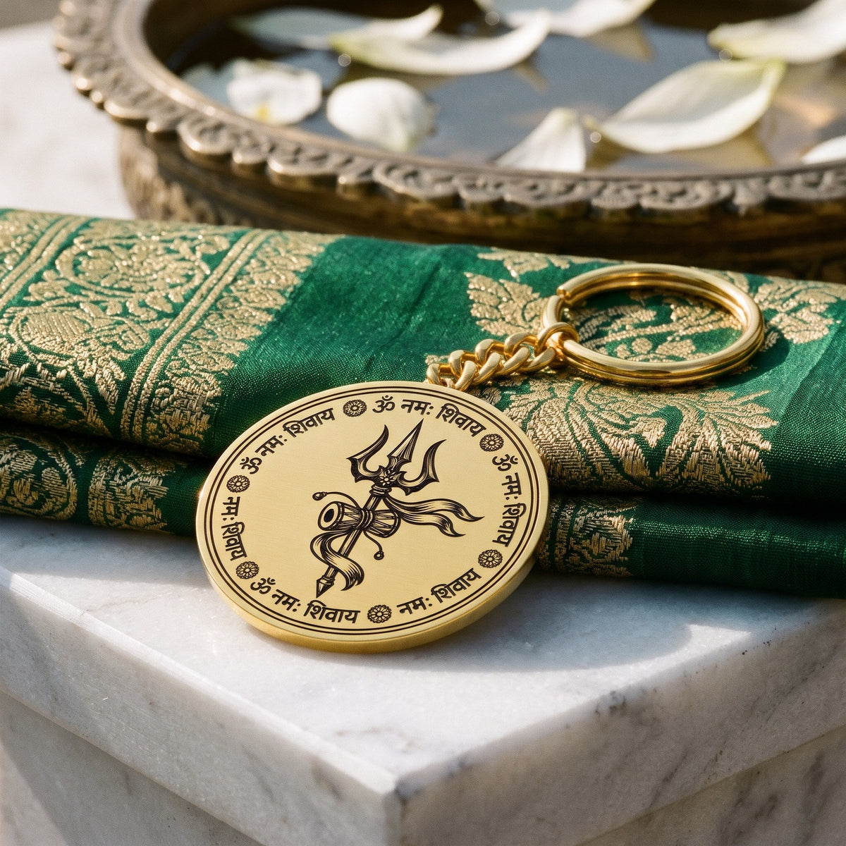 Close view of the Om Namah Shivaya trishul engraving on a round gold keychain